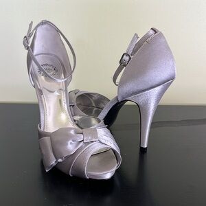 I Miller silver heeled sandal with an ankle strap and a bow detail on open toe